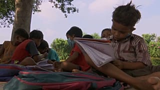 تلميذ يتلقى درسا على جانب أحد طرقات العاصمة الهندية
