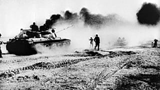 Irak tankları, 22 Ekim 1980'de İran'ın güney batısındaki Karun Nehri'ni geçmeye çalışıyor. Vurulan petrol boru hattından ise dumanlar yükseliyor.