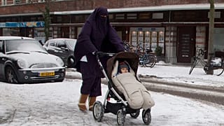 FILE - In this Monday Jan. 21, 2013 file photo, a woman wearing a full-face veil known as niqab, pushes a baby stroller on snow-covered streets in Amsterdam, Netherlands.