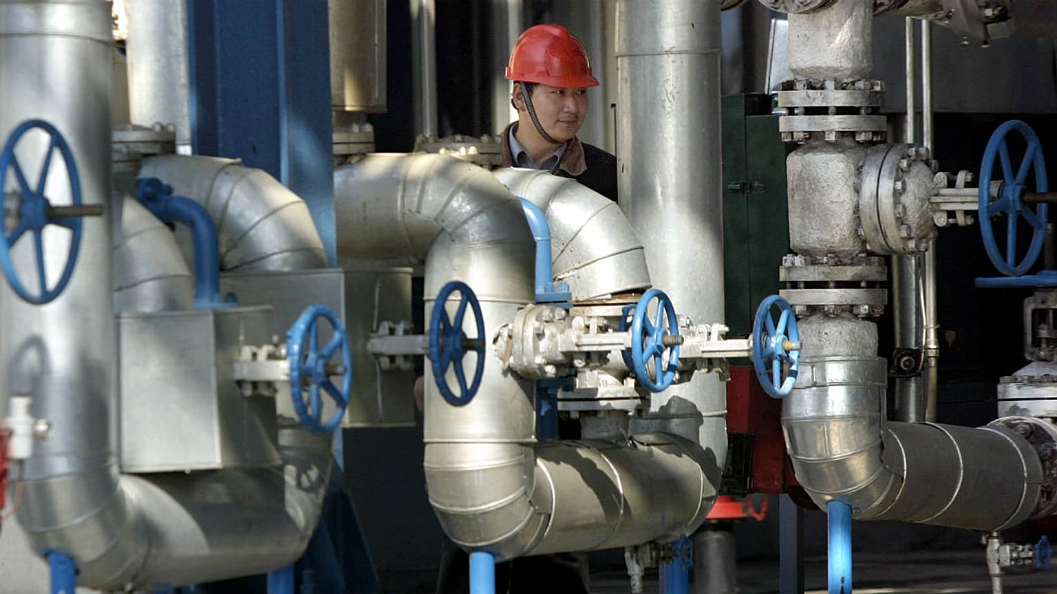 A Chinese worker walks past equipment at an oil refinery of the PetroChina