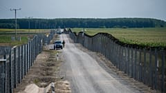 Katonák járőrőznek a határzár mellett a magyar-szerb határon 2020. július 16-án.
