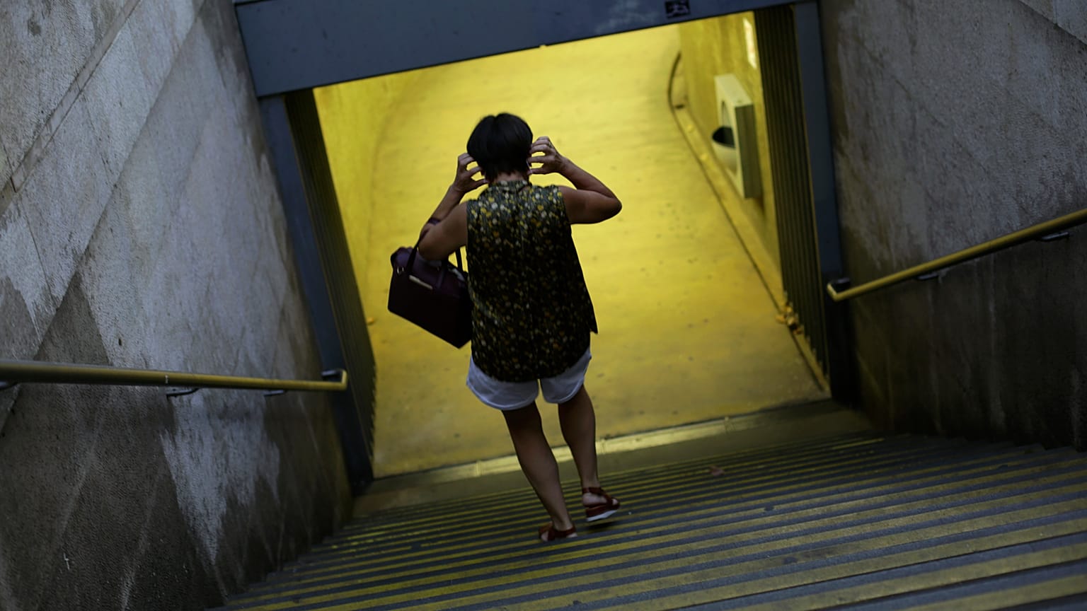 Uma mulher coloca uma máscara à entrada do Metro em Lisboa