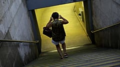 Uma mulher coloca uma máscara à entrada do Metro em Lisboa