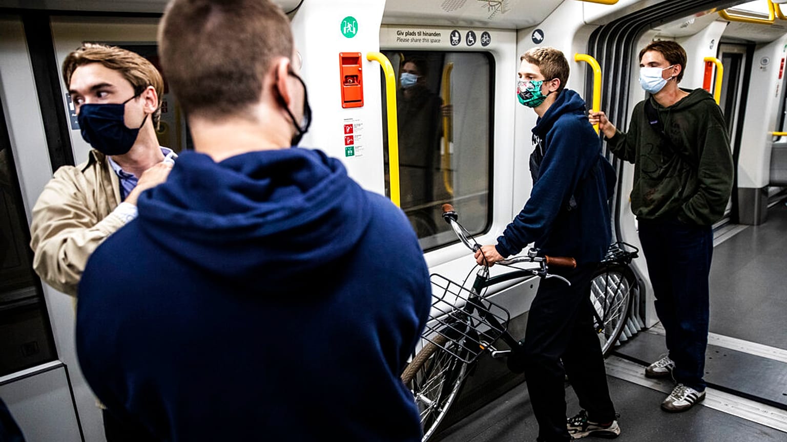People wearing face masks ride a metro in Copenhagen, Denmark