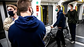 People wearing face masks ride a metro in Copenhagen, Denmark