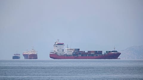 A cargo ship approaches the port of Piraeus as other ships are anchored, near Athens, Greece in this May 26, 2020 file photo.