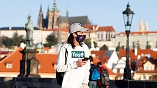 Maszkban sétáló fiatal Prágában