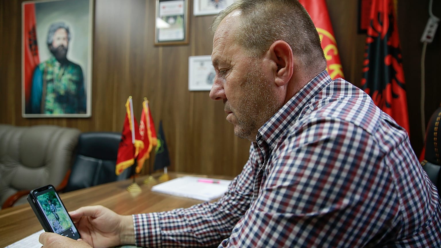 Hysni Gucati head of the War Veterans Organization of the Kosovo Liberation Army looks at a photo of former Kosovo Liberation Army commander Salih Mustafa after his arrest.