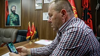 Hysni Gucati head of the War Veterans Organization of the Kosovo Liberation Army looks at a photo of former Kosovo Liberation Army commander Salih Mustafa after his arrest.