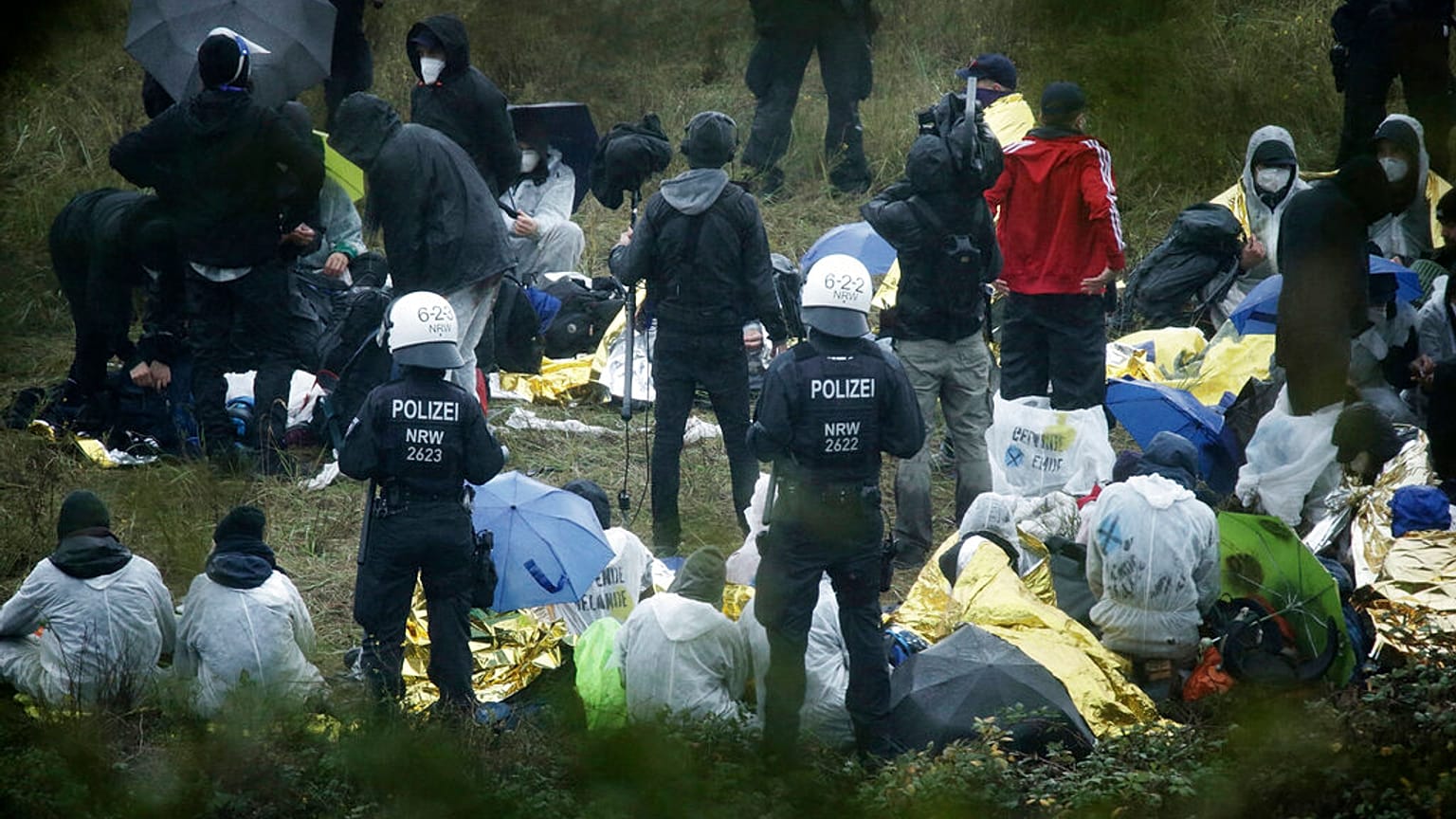 Activists are surrounded by police on the Garzweiler power plant grounds in Grevenbroich, western Germany, Saturday, Sept. 26, 2020.