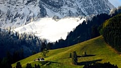 De la neige fraîche est visible sur les pentes de la montagne Moleson, près des pâturages encore verts, le samedi 26 septembre 2020, à Moleson, en Suisse. 