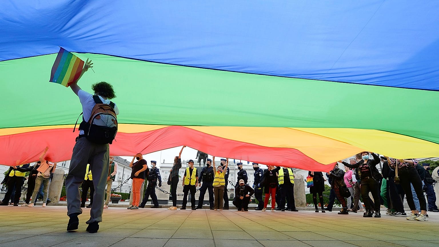 Pro-LGBT demonstrators display a huge rainbow flag as they take part in a protest against hatred towards LGBT people in Warsaw on August 30, 2020.