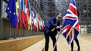 Un membre du protocole retire le drapeau du Royaume-Uni du bâtiment Europa à Bruxelles, le 31 janvier 2020, alors qu'il a mis fin à ses 47 ans d'appartenance à l'UE.