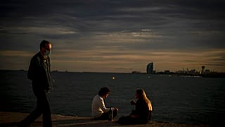 Una pareja y un paseante en el muelle de Barcelona este 27 de septiembre