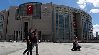 People walk outside a court in Istanbul.