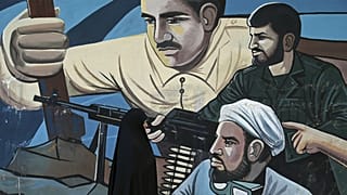A woman walks past of a mural depicting members of Iran's Basij volunteer paramilitary force, in downtown Tehran, Iran
