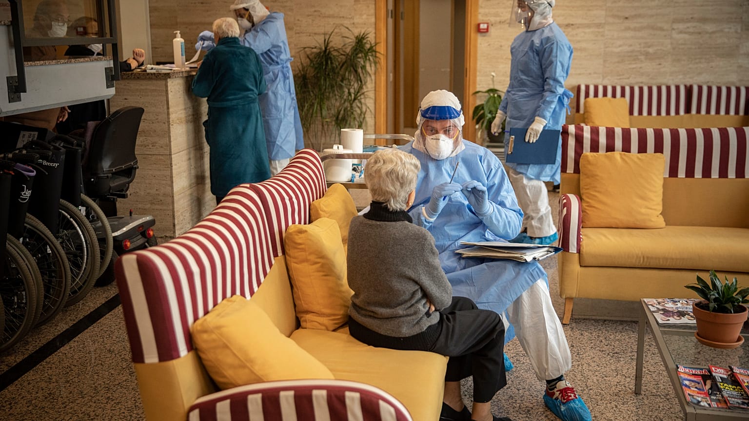 En esta foto tomada el miércoles 1 de abril de 2020, un cooperante de la ONG española Brazos Abiertos habla con una anciana antes de una prueba en una residencia de mayores.