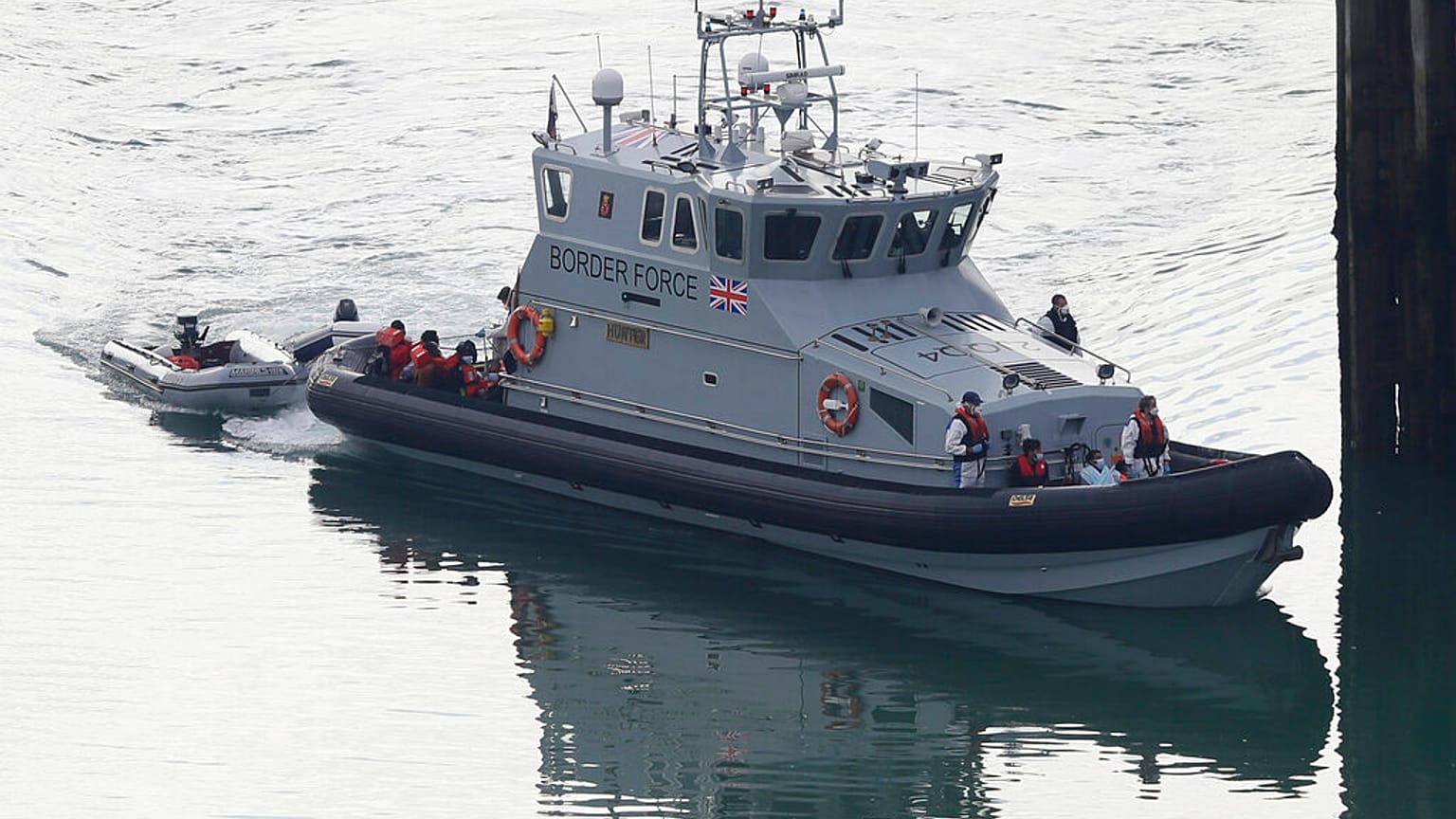 A Border Force vessel brings a group of people thought to be migrants into the port city of Dover, England, from small boats, Saturday Aug. 8, 2020.