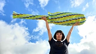 Ella Daish holds her giant 1.8m tampon applicator made from period plastic. 