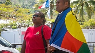 Le drapeau Kanak avec en arrière plan le drapeau français. Photo prise lors du référendum de 2018