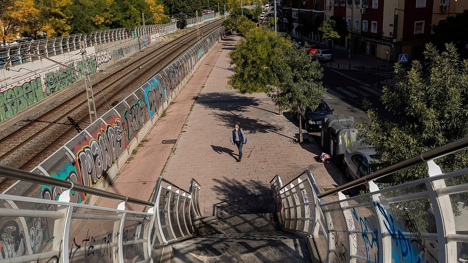 Un hombre con mascarillas camina en solitario por el barrio de Vallecas, en el sur de Madrid