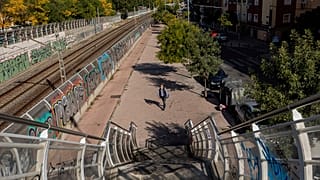 Un hombre con mascarillas camina en solitario por el barrio de Vallecas, en el sur de Madrid