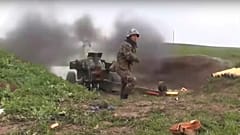 an Armenian serviceman fires a cannon