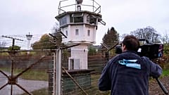 A cameraman films a control tower of the former GDR border guard forces in Moedlareuth prior to the 30th anniversary of the falling of the Berlin wall