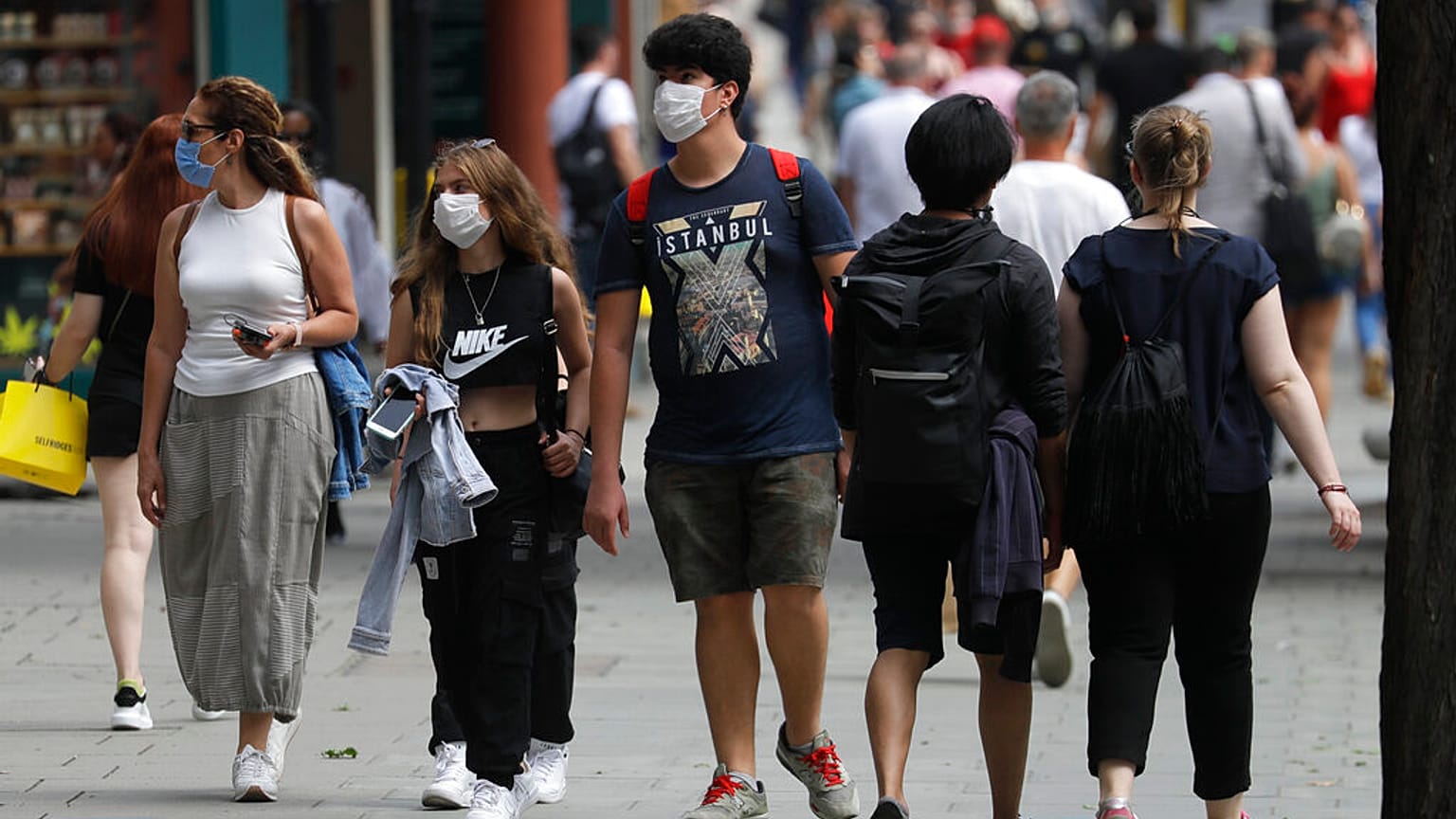 FILE - In this Thursday, Aug. 13, 2020 file photo, shoppers walk along Oxford Street in London.