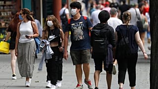 FILE - In this Thursday, Aug. 13, 2020 file photo, shoppers walk along Oxford Street in London.