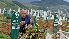 Tarik Svraka visits the graves of his parents in law who died of COVID-19 related complications, in Zenica, Bosnia, Monday, Sept. 28, 2020. 