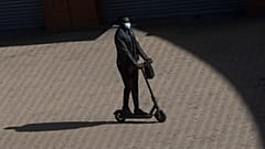 A passenger arrives at Atocha rail station on an electric scooter in Madrid, Spain, Saturday, Oct. 3, 2020.