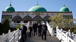 أقلية الهوي أمام مسجد في ينتشوان بمنطقة نينغشيا ذاتية الحكم في شمال غرب الصين.