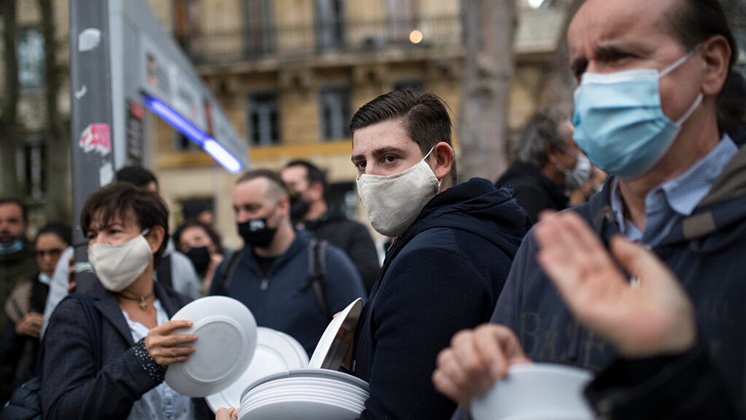 Restaurant and bar owners bang plates together and chant at a demonstration against restaurant and bar closures in Marseille, southern France, Friday Oct. 2, 2020.