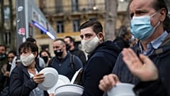 Restaurant and bar owners bang plates together and chant at a demonstration against restaurant and bar closures in Marseille, southern France, Friday Oct. 2, 2020.