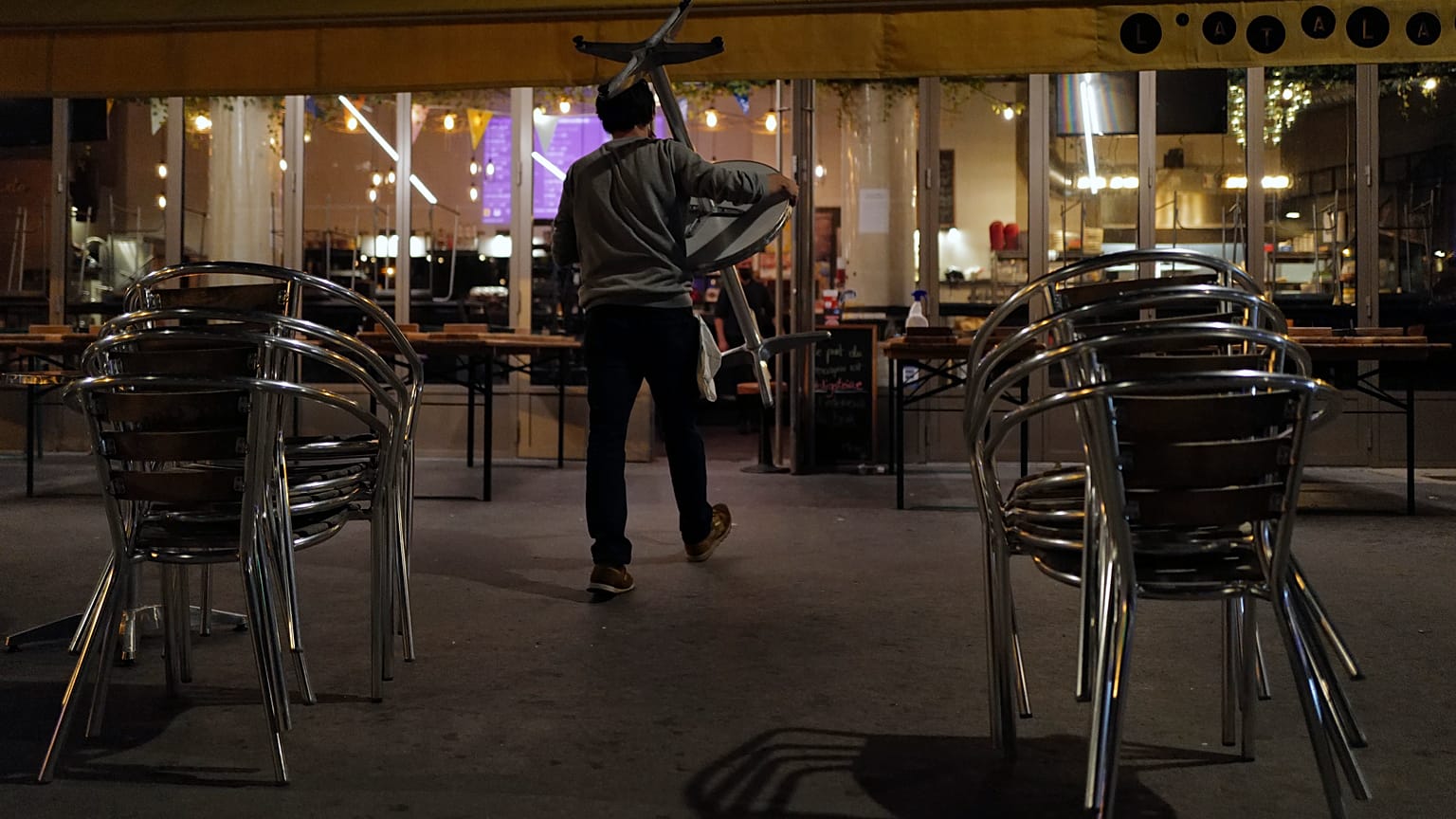 Philippe Cotonnec del Bar Atalante carga mesas para cerrar una terraza del bar en París, el lunes 28 de septiembre de 2020.