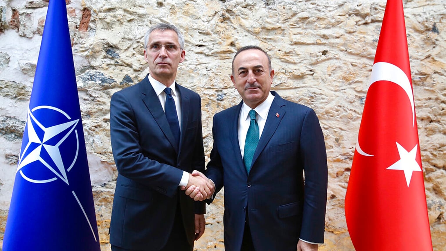 Turkish Foreign Minister Mevlut Cavusoglu, right, shakes hands with NATO Secretary General Jens Stoltenberg 