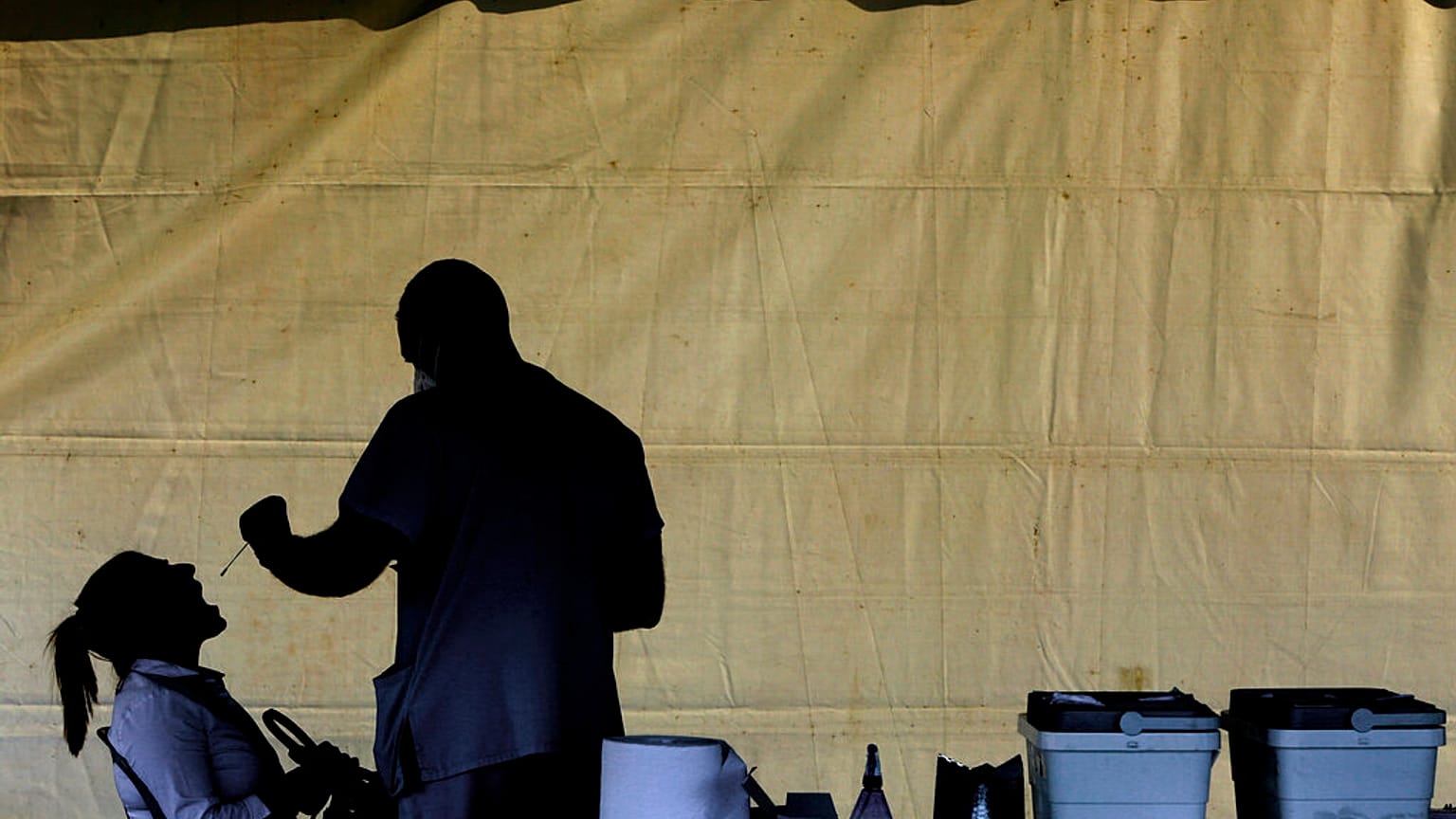 A health worker carries out a COVID-19 test of a resident of Larnaca