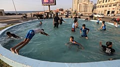 أطفال يسبحون في إحدى نوافير غزة 