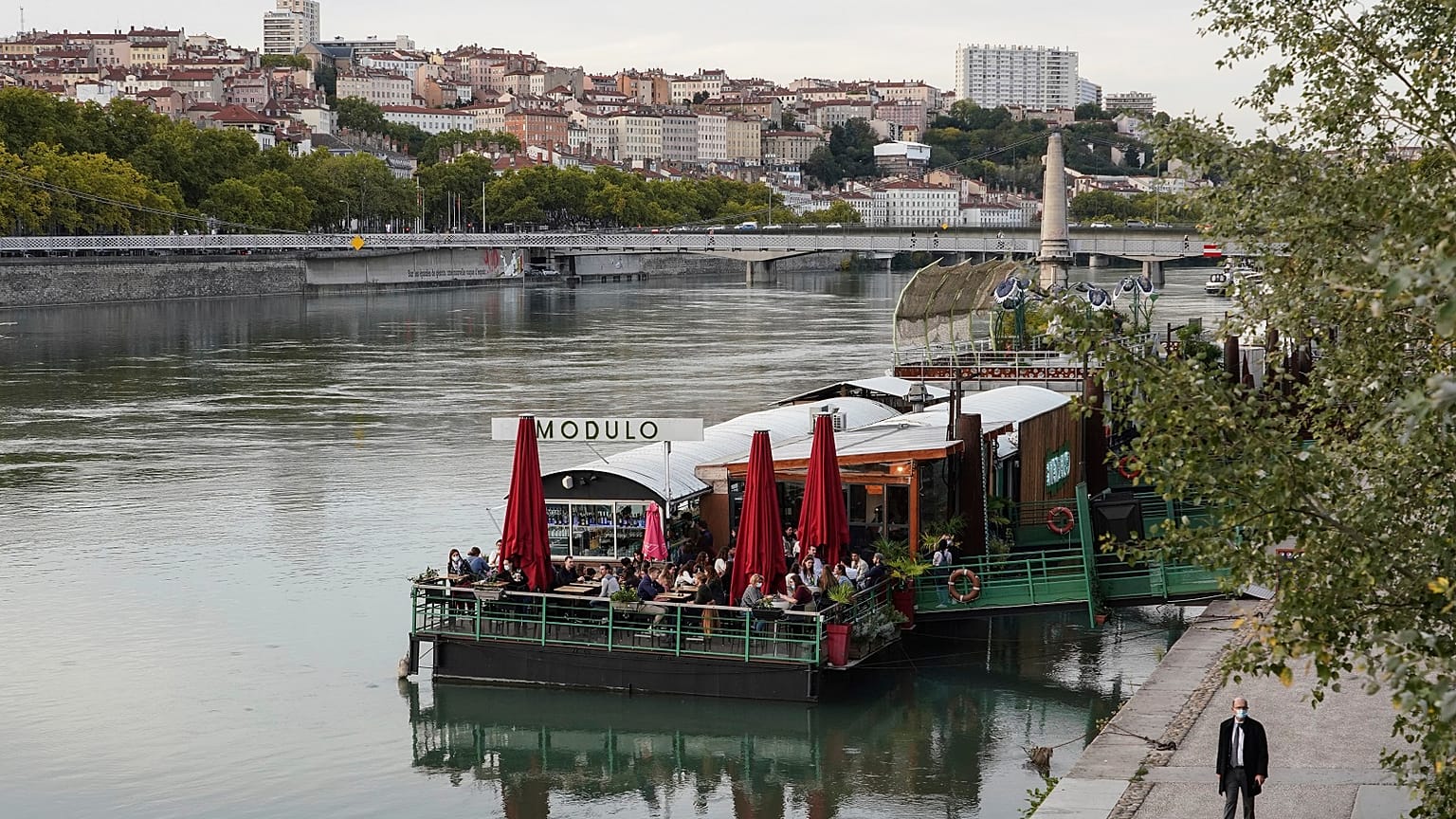 People enjoy a drink on a boat in the centre of Lyon, central France, Thursday, October 8, 2020. 
