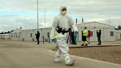 Védőruhába öltözött rendőr a tiszaújvárosi konténerlakótelepen 2020. október 8-án