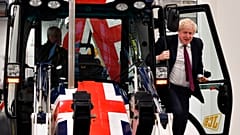 Boris Johnson exits the cab of a Union flag-themed JCB during an election campaign event at the JCB manufacturing plant in Uttoxeter, England, December 10, 2019. 