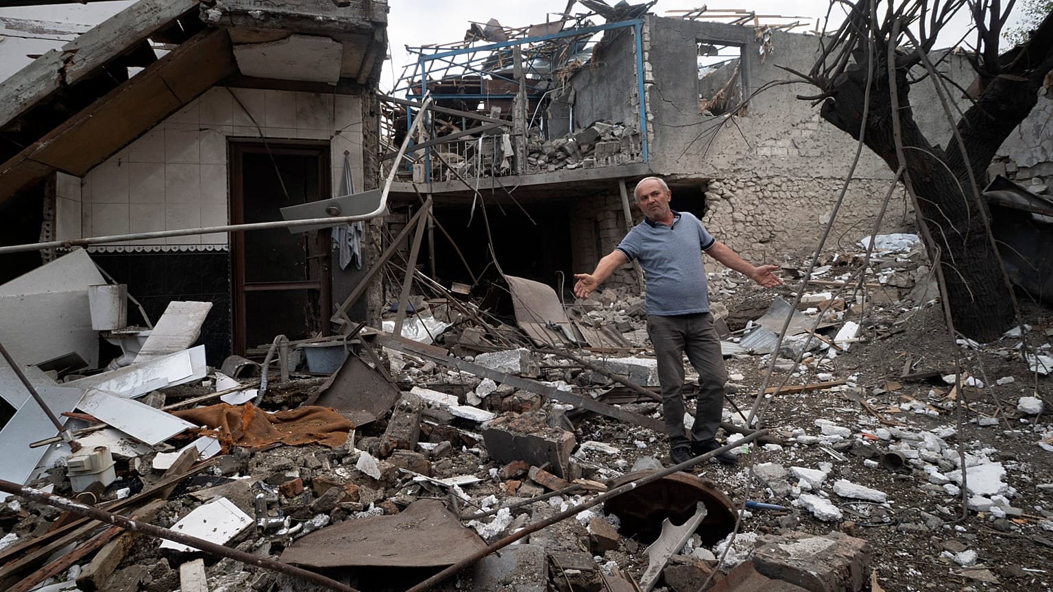 A man gestures in the yard of a house destroyed by shelling by Azerbaijan's artillery during a military conflict in Stepanakert, in Nagorno-Karabakh, Oct. 9, 2020.