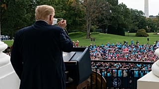 President Donald Trump removes his mask before speaking from the Blue Room Balcony of the White House to a crowd of supporters, Saturday, Oct. 10, 2020, in Washington.