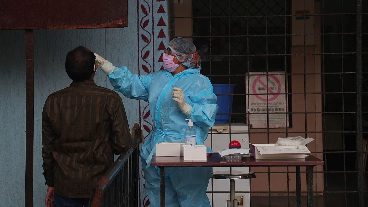 A health worker takes a nasal swab sample at a COVID-19 testing center in Hyderabad, India