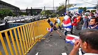Varios manifestantes golpean las vallas de protección en la Casa Presidencial