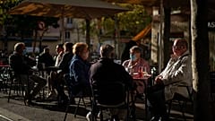 Customers wearing masks to prevent the spread of the coronavirus sit in a terrace bar in Barcelona, Spain,
