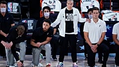 Assistenztrainerin Becky Hammon mit knieenden Spielern der San Antonio Spurs vor einem Match gegen die Memphis Grizzlies im August 2020