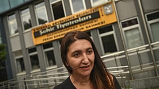 Actress Ruges Kirici speaks to media in front of Istanbul metropolitan municipality theatre building.