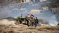 فلسطينيون بالقرب من نابلس يبتعدون عن قنابل مسيلة للدموع أطلقها عليهم الجيش الإسرائيلي 